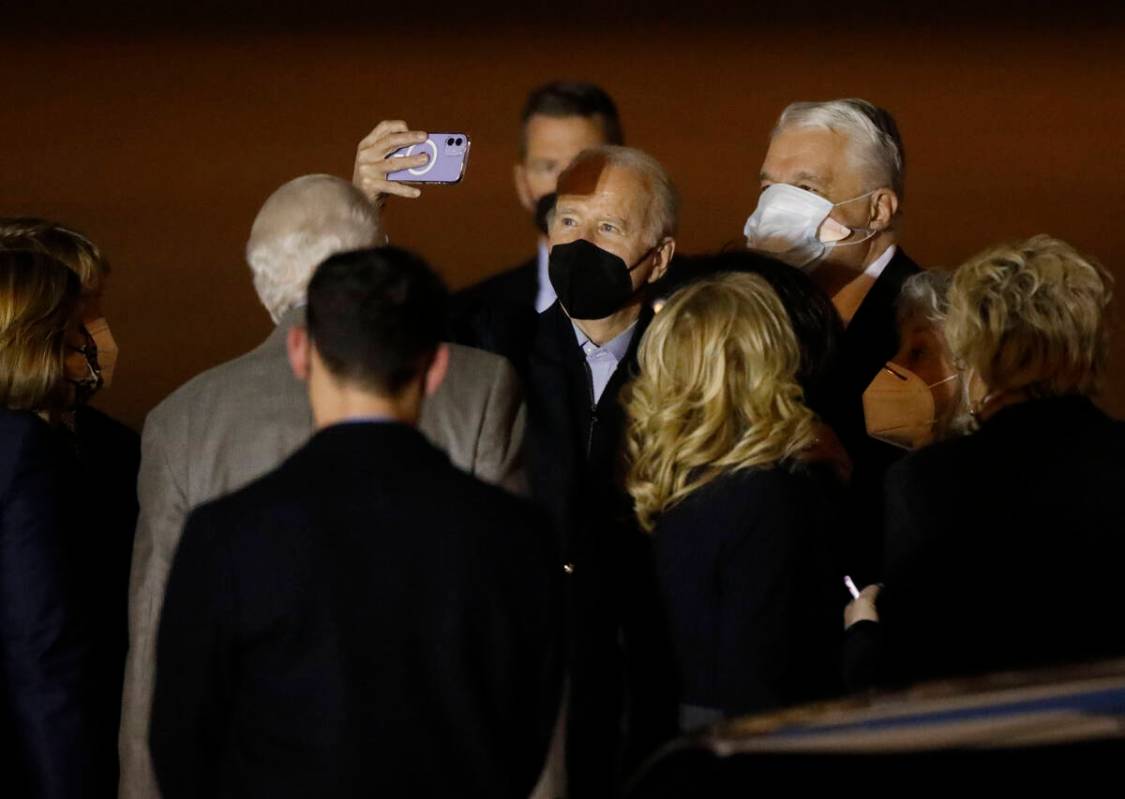 President Joe Biden, center, takes a selfie with people including Nevada Gov. Steve Sisolak, ri ...