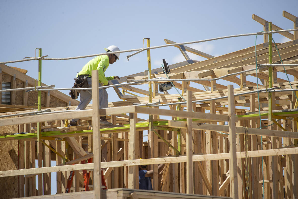 A construction worker build the roof of a home near West Elkhorn Road and North Aviary Way in N ...