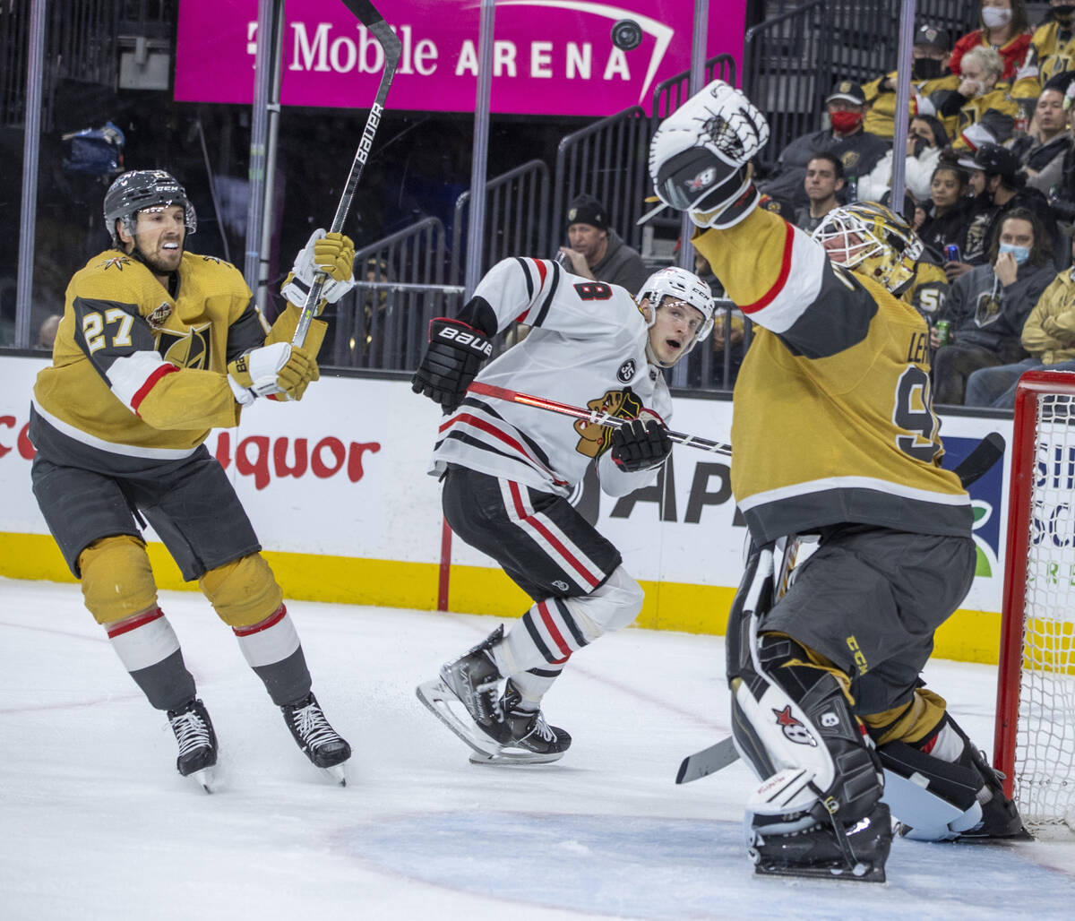 Golden Knights goaltender Robin Lehner (90) nabs a high puck as Chicago Blackhawks left wing Do ...