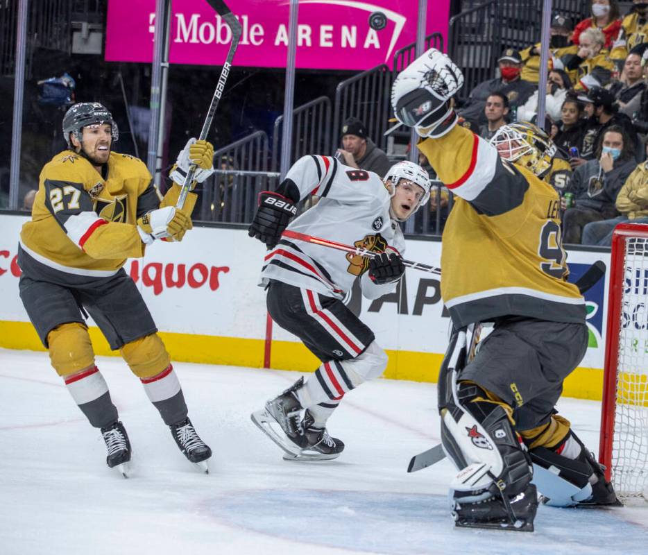 Golden Knights goaltender Robin Lehner (90) nabs a high puck as Chicago Blackhawks left wing Do ...