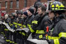 Firefighters work at the scene of a fatal fire at an apartment building in the Bronx on Sunday, ...