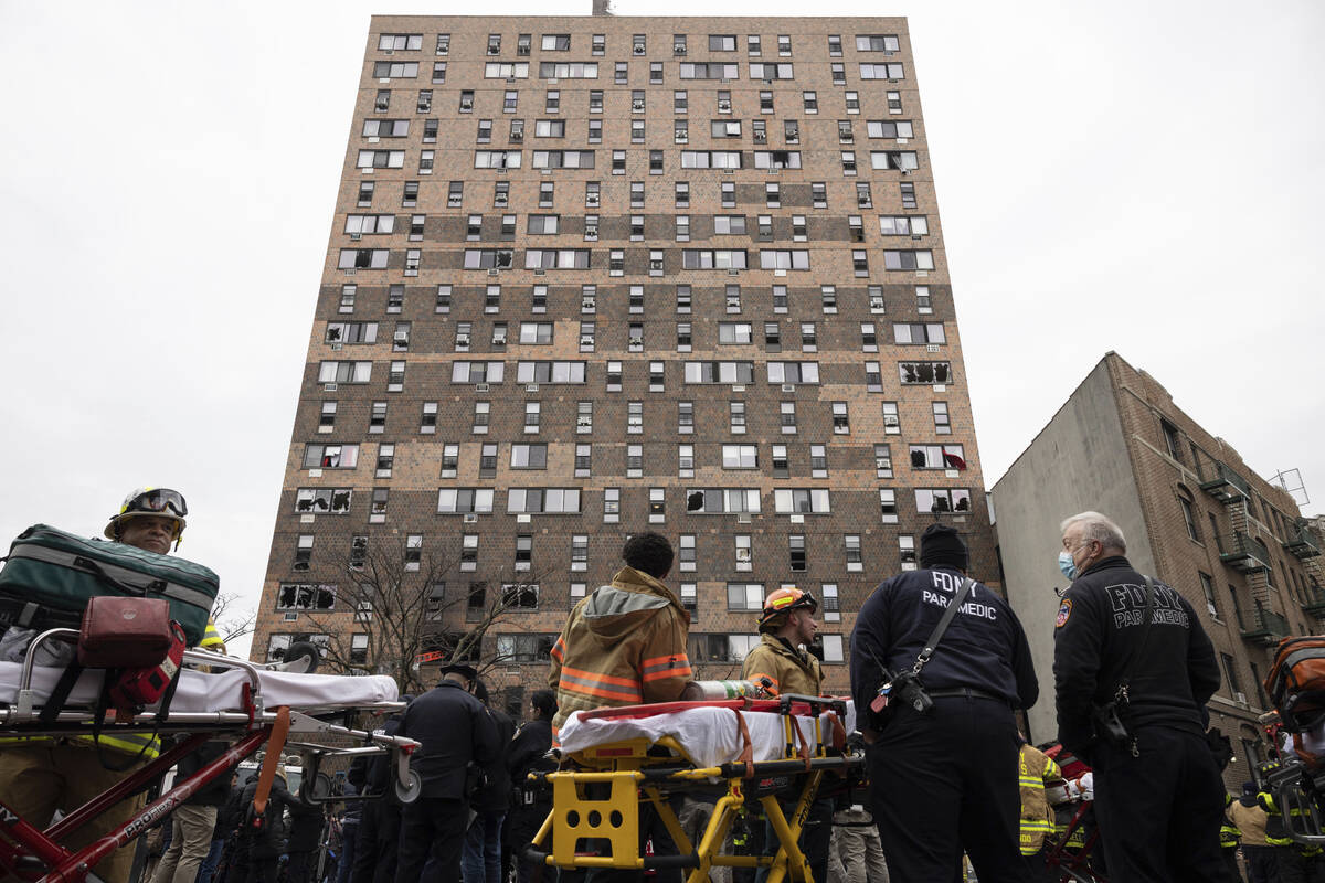 Emergency personnel work at the scene of a fatal fire at an apartment building in the Bronx on ...