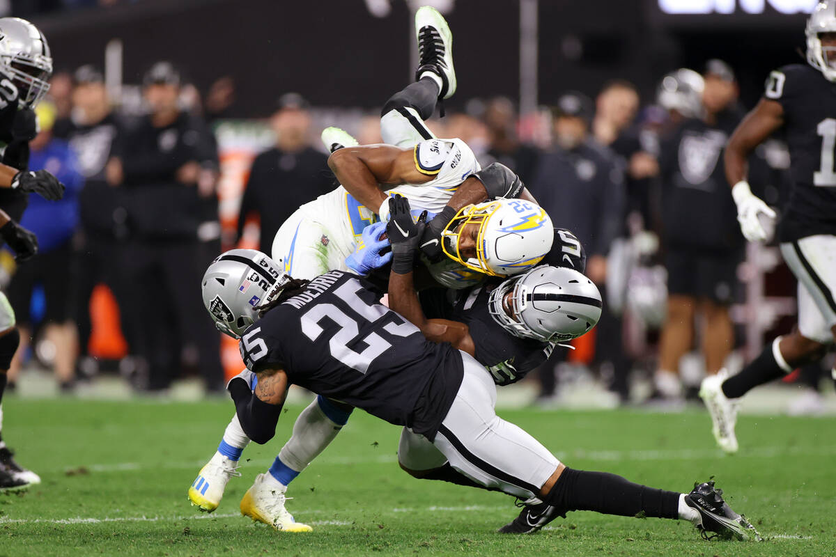 Raiders linebacker Divine Deablo (5) and free safety Trevon Moehrig (25) tackle Los Angeles Cha ...