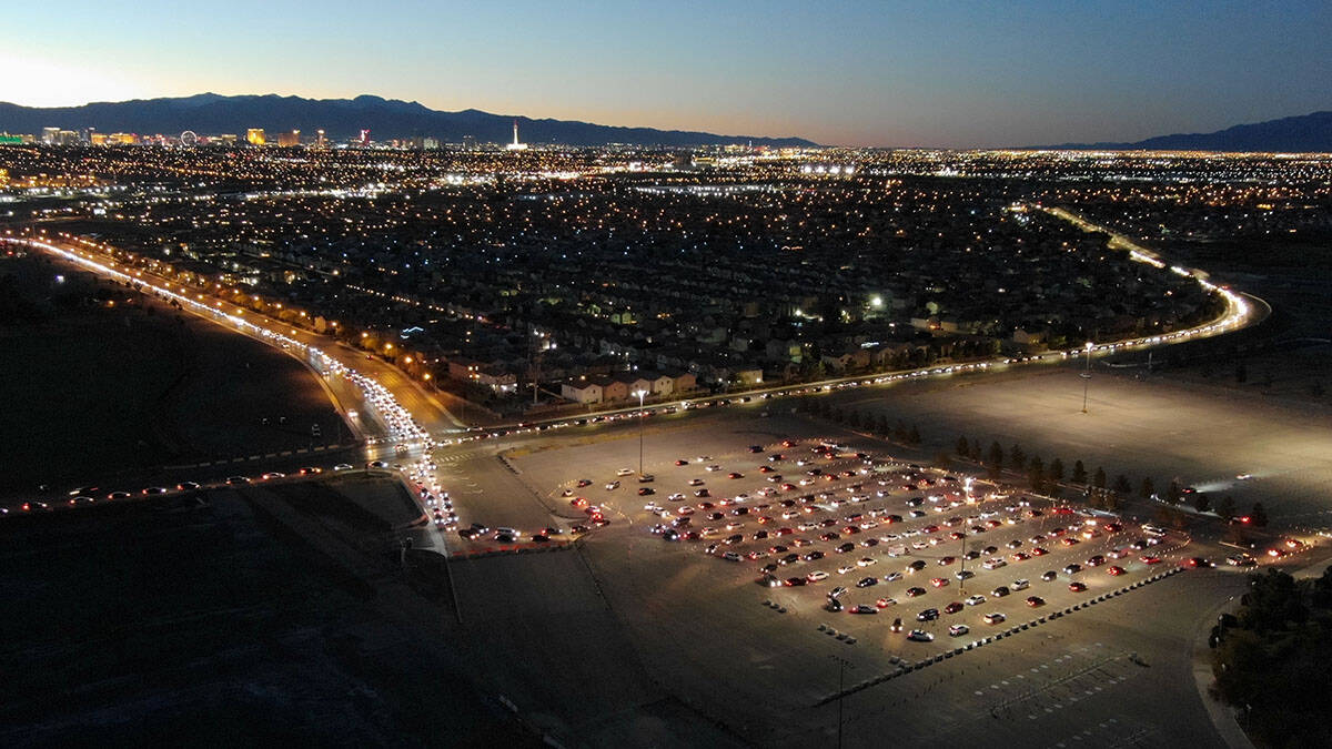 An aerial view of cars lined up from three different directions for the drive-thru COVID testin ...