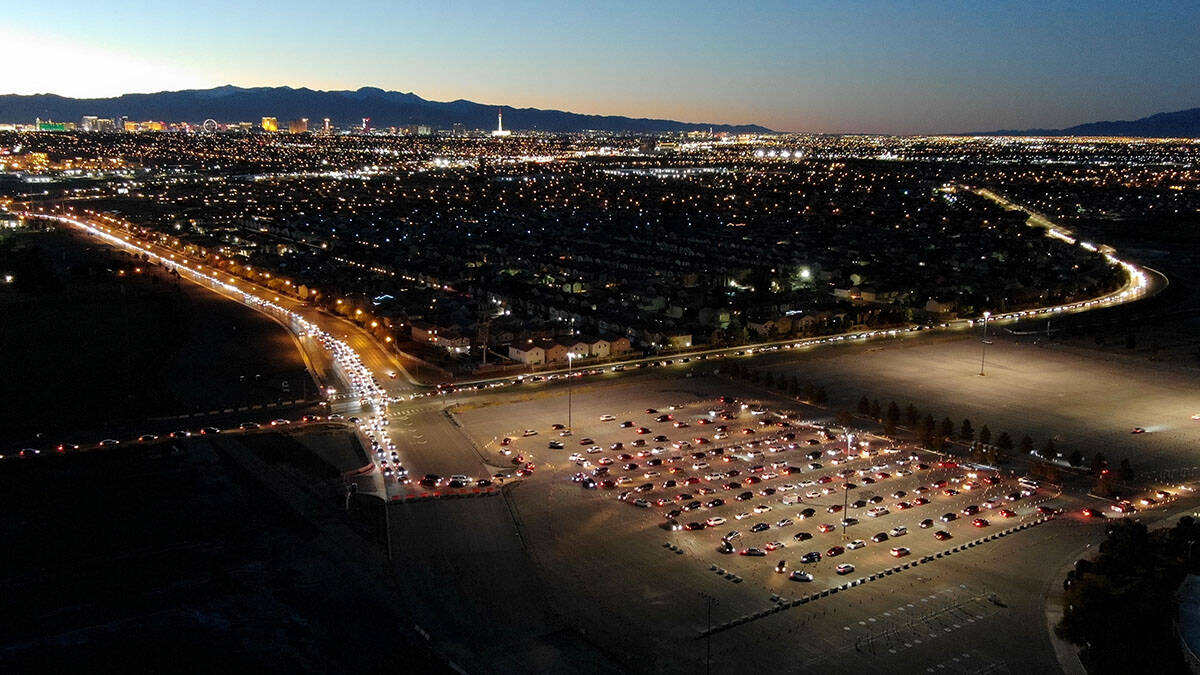 An aerial view of cars lined up from three different directions for the drive-thru COVID testin ...