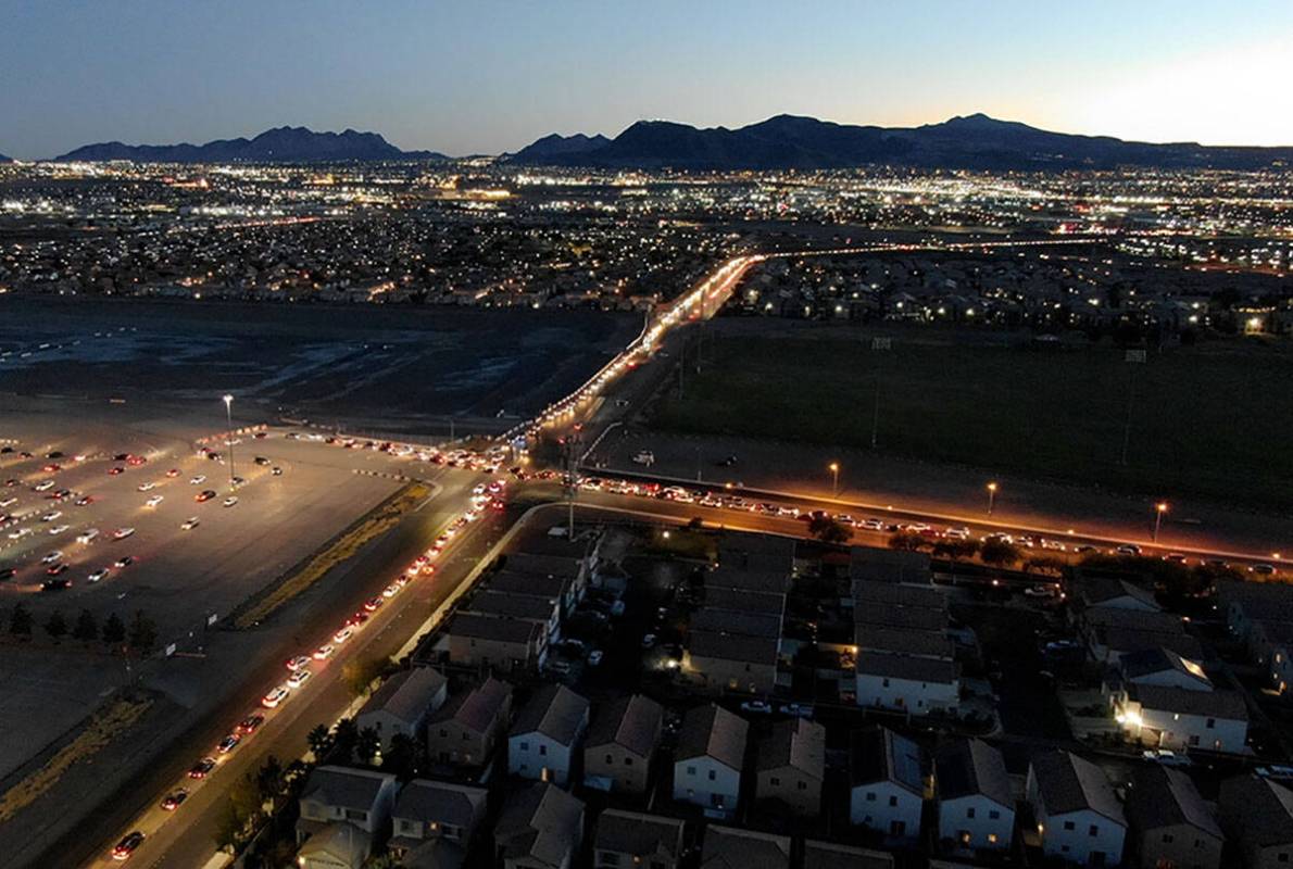 An aerial view of cars lined up from three different directions for the drive-thru COVID testin ...