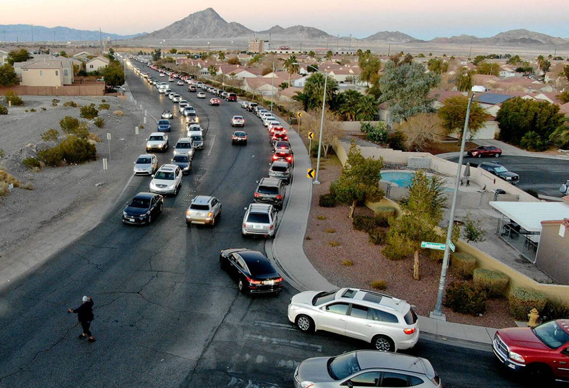 T'onna John helps direct traffic as hundreds of cars line up for the drive-thru COVID testing s ...