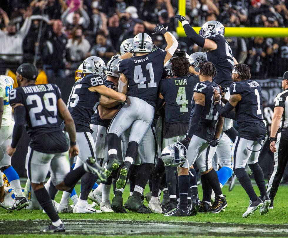 Raiders players pile on as they celebrate a winning overtime field goal by Los Angeles Chargers ...