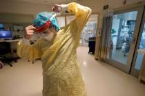 Registered nurse Sara Nystrom, of Townshend, Vt., prepares to enter a patient's room in the COV ...