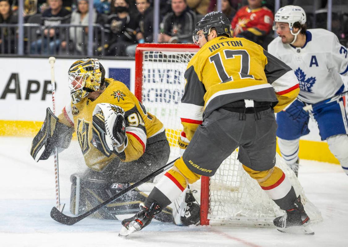 Golden Knights goaltender Robin Lehner (90) looks to make a stop with Golden Knights defenseman ...