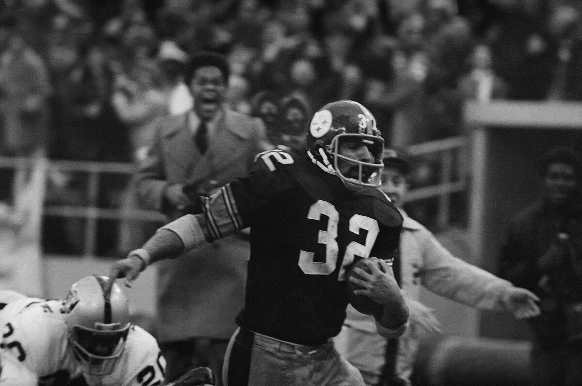 Franco Harris (32) of the Pittsburgh Steelers eludes a tackle by Jimmy Warren of the Oakland Ra ...