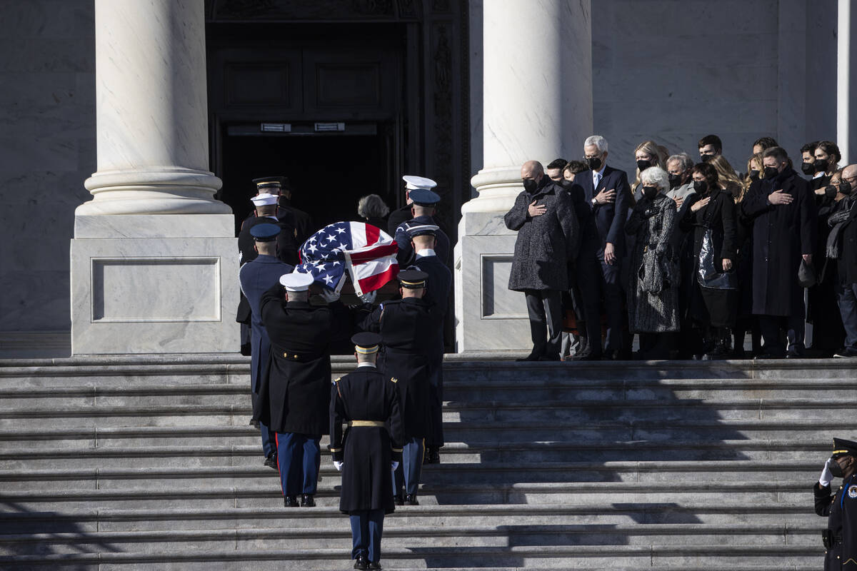 Family members look on as a military honor guard carries the flag-draped casket of of former U. ...