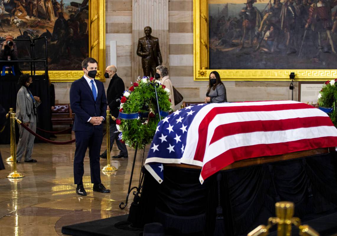 Pete Buttigieg, Secretary of Transportation, pays respects while viewing the flag-draped casket ...