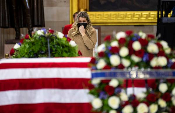 A woman pays respects while viewing the flag-draped casket of former Sen. Harry Reid as he lies ...