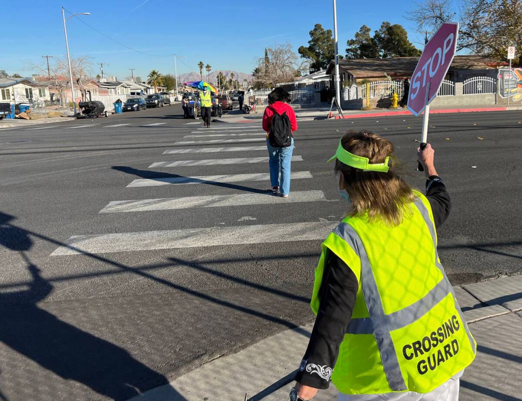 Crossing Guard Connie Walsh helps a student cross the street at Warren Elementary School in Las ...