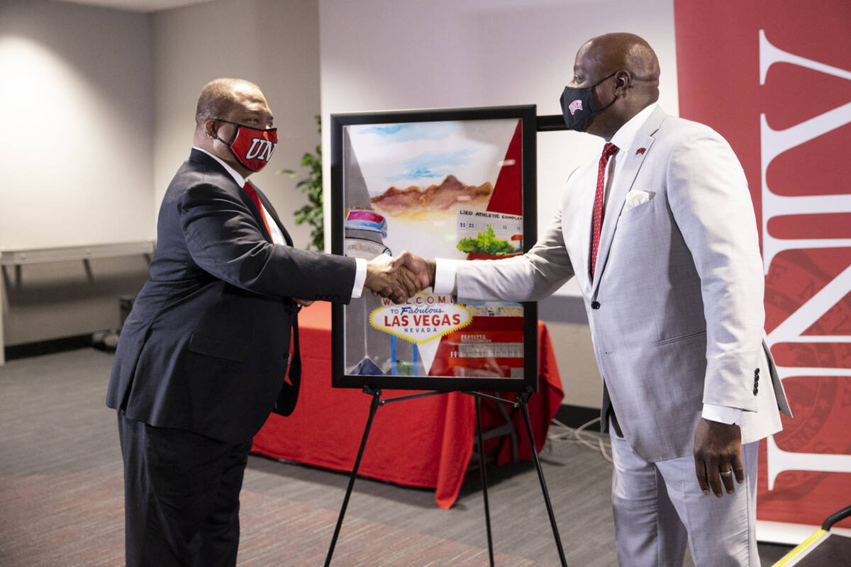 UNLV President Keith Whitfield, left, shakes hands with the newly announced Director of Athleti ...