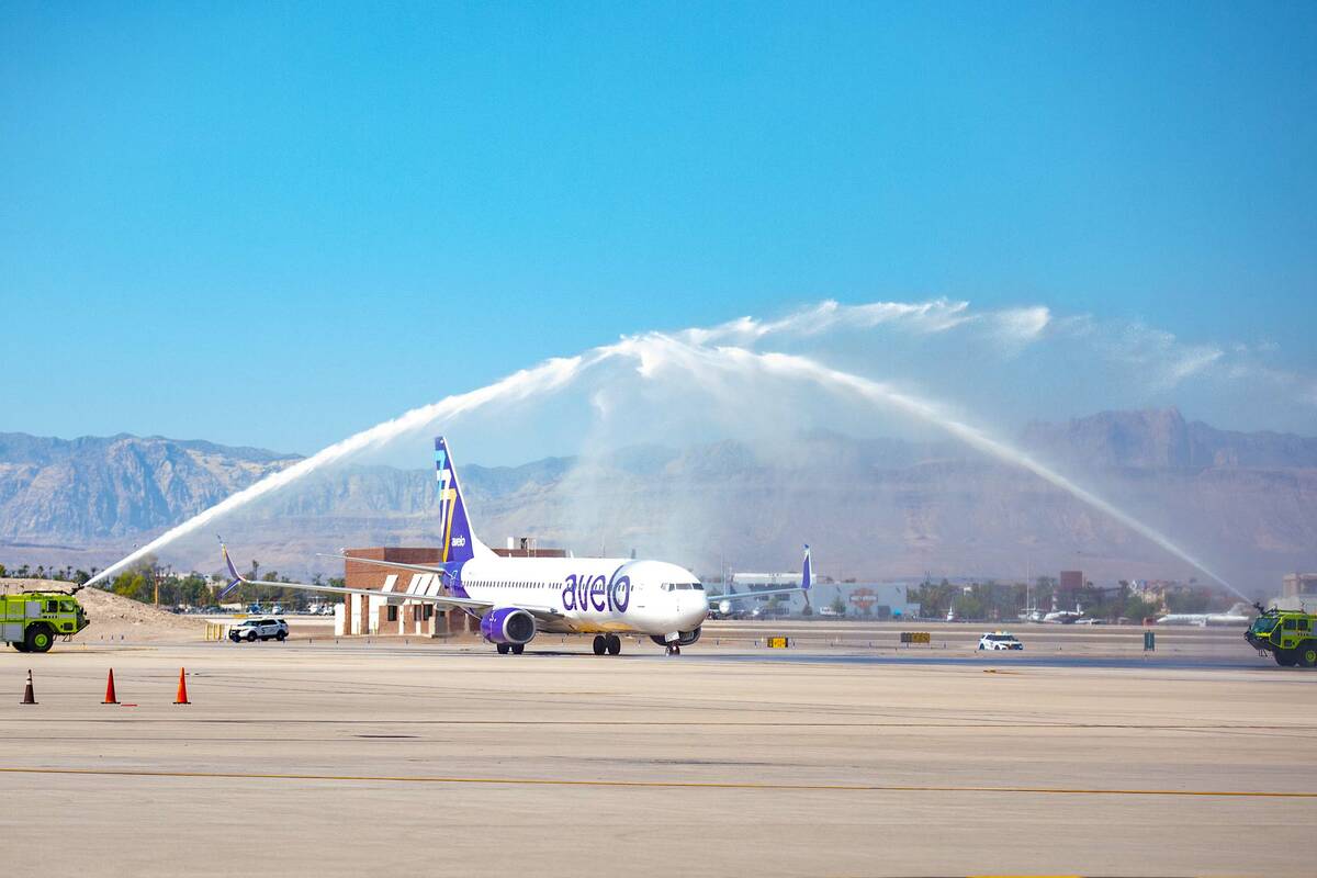 A Boeing 737-800 jet operated by Avelo Airlines taxis beneath a water arch at McCarran Internat ...