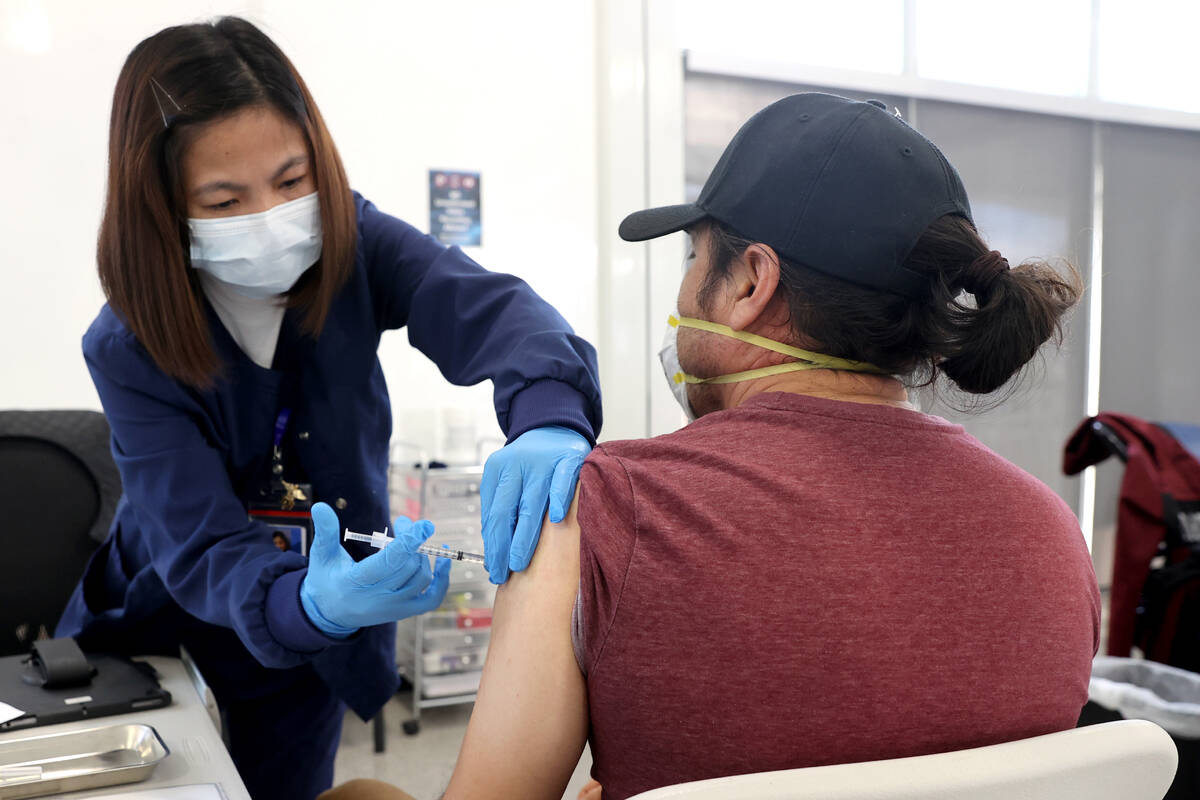 Maria Mendoza gives a shot to Javier De La Torre of Las Vegas at a COVID-19 vaccination station ...