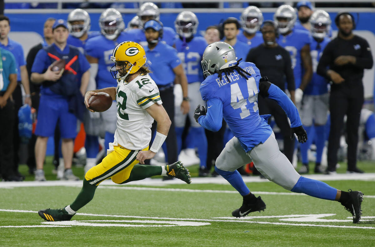 Green Bay Packers quarterback Aaron Rodgers (12) is pursued by Detroit Lions inside linebacker ...
