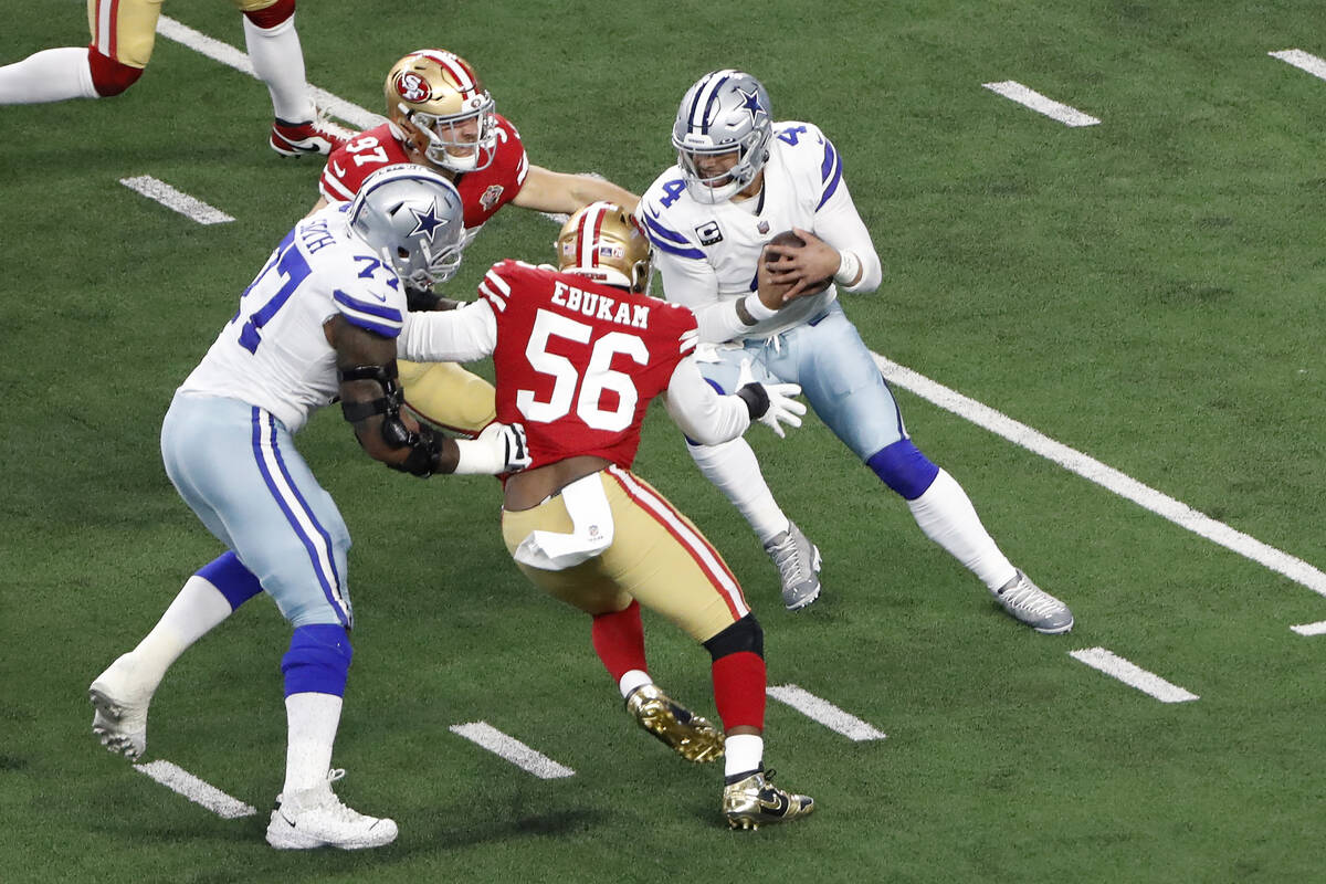 Dallas Cowboys quarterback Dak Prescott, right, is pressured by San Francisco 49ers defensive e ...