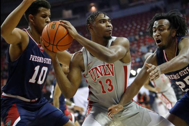 UNLV Rebels guard Bryce Hamilton (13) keeps a ball away from Fresno State Bulldogs forward Orla ...