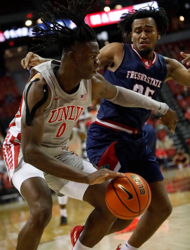 UNLV Rebels forward Victor Iwuakor (0) keeps a ball away from Fresno State Bulldogs guard Anth ...