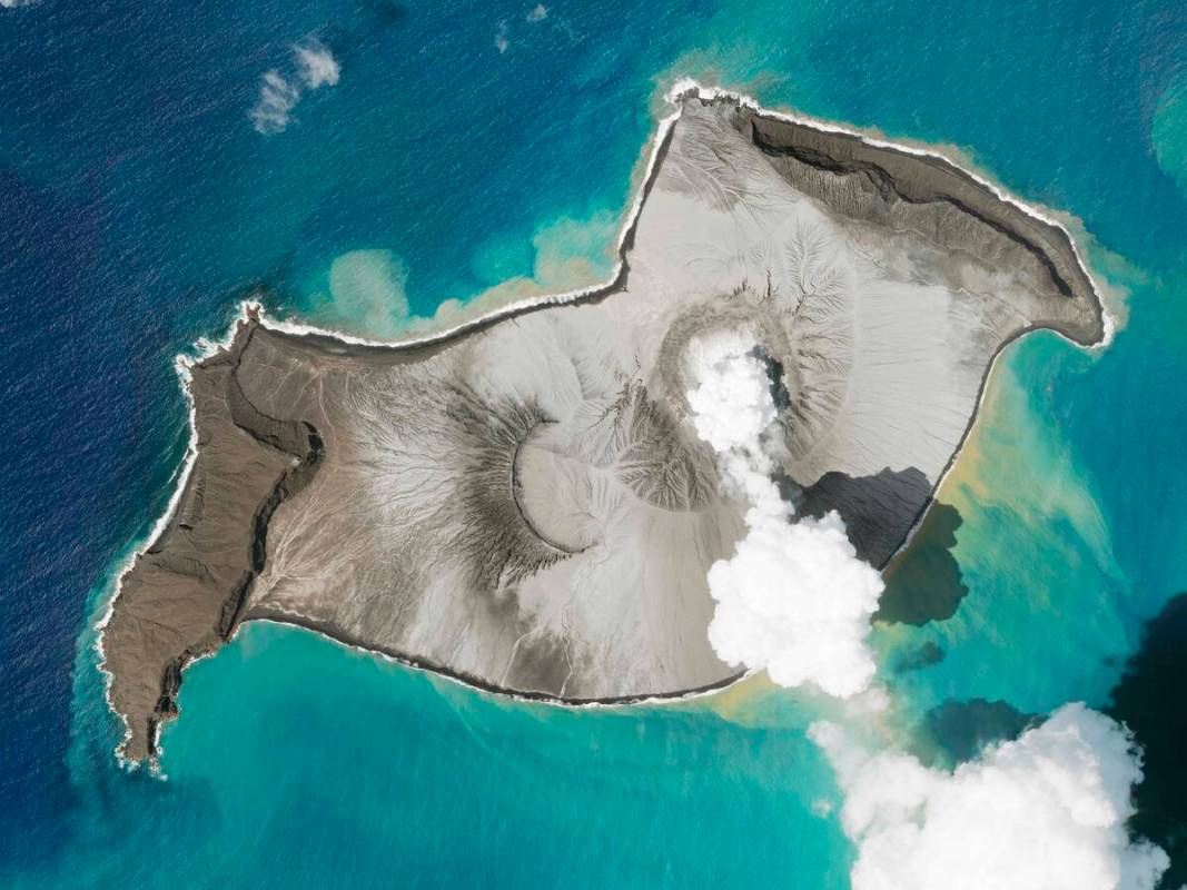 In this satellite photo taken by Planet Labs PBC, an island created by the underwater Hunga Ton ...