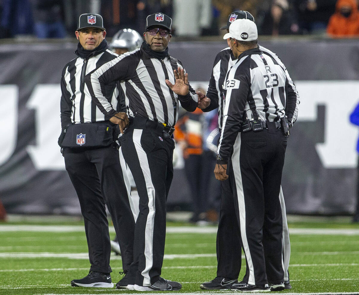 NFL referees discuss a penalty flag thrown during the second half of an NFL playoff game betwee ...