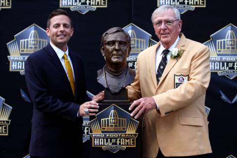 Former NFL contributor Ron Wolf, right, poses with a bust of himself and presenter, son, Eliot ...