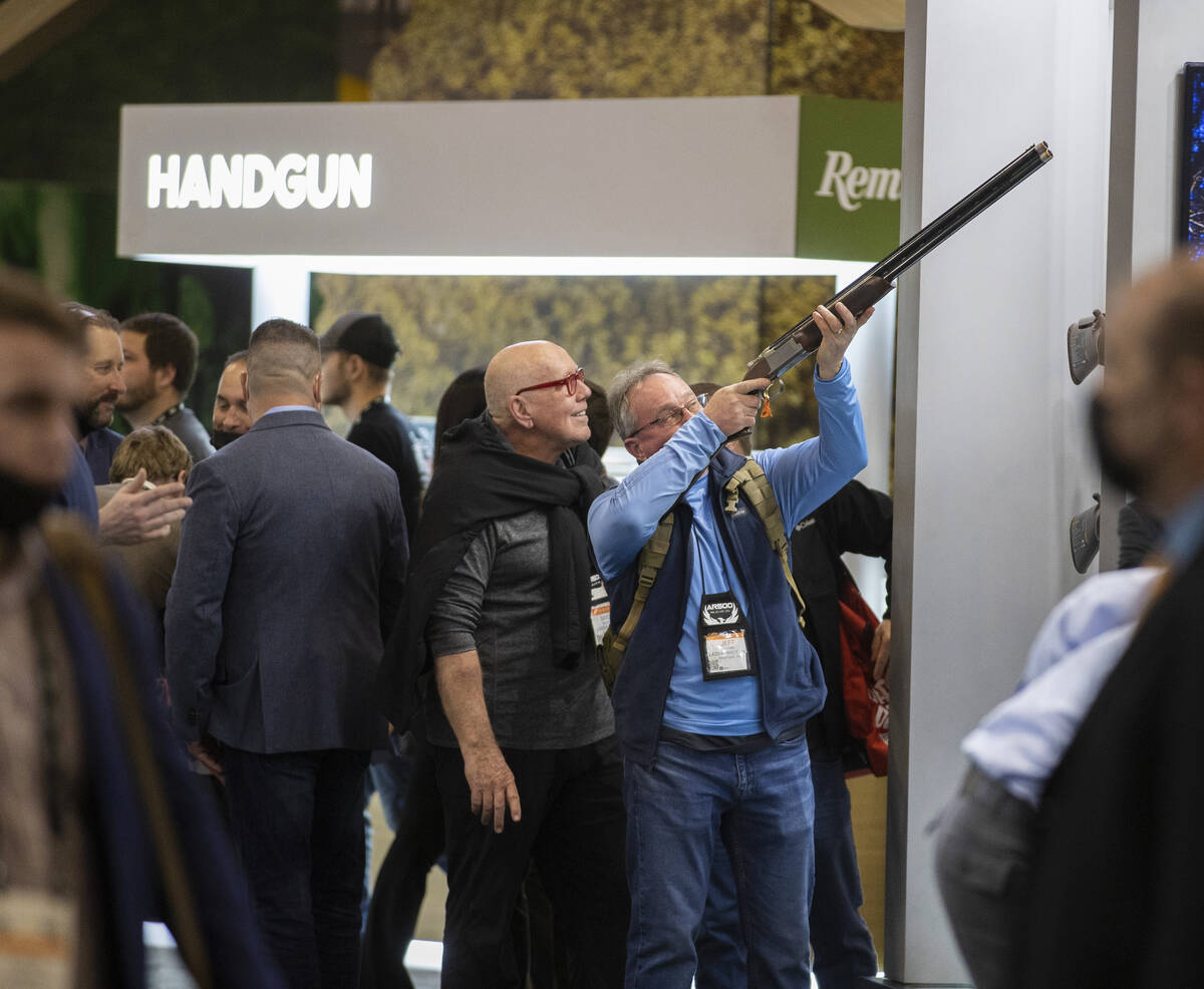 Jeff Alford, right, with Laser Shot, looks at Browning shotguns during the SHOT Show shooting, ...