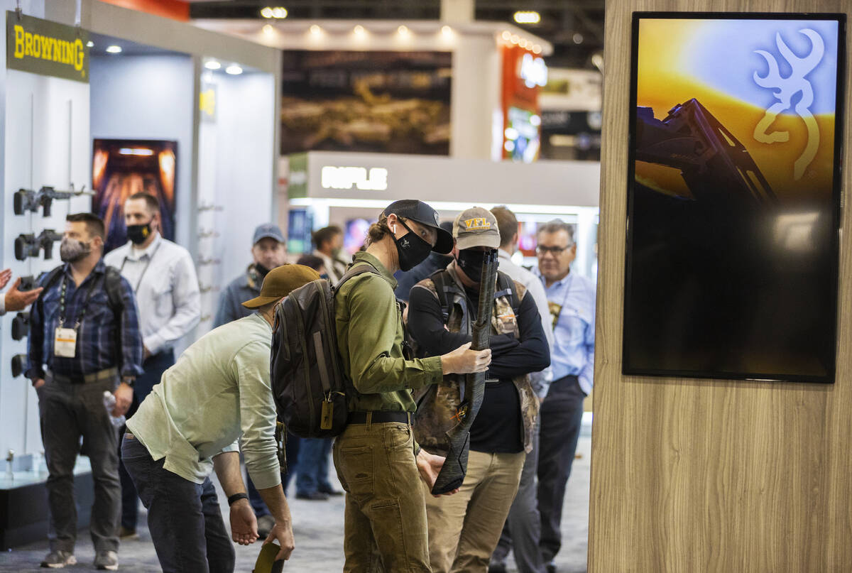 People look at Browning shotguns during the SHOT Show shooting, hunting and outdoor trade show ...