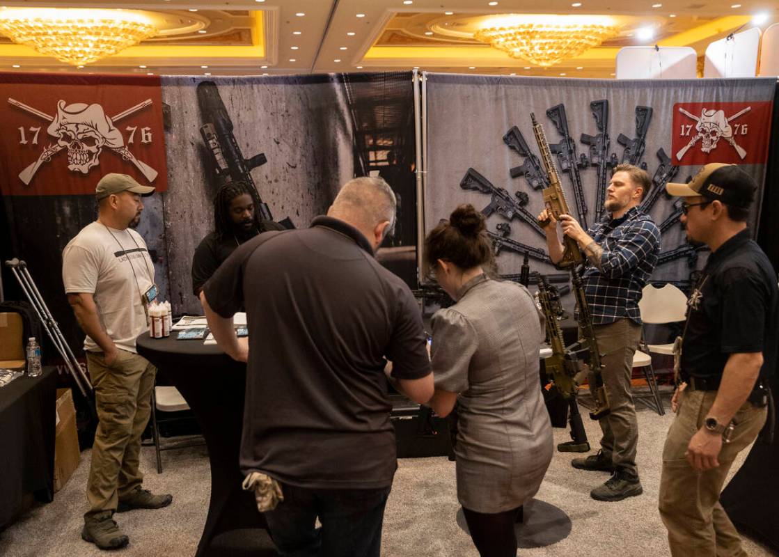People look at guns at Sons of Liberty Gun Works during the SHOT Show shooting, hunting and out ...