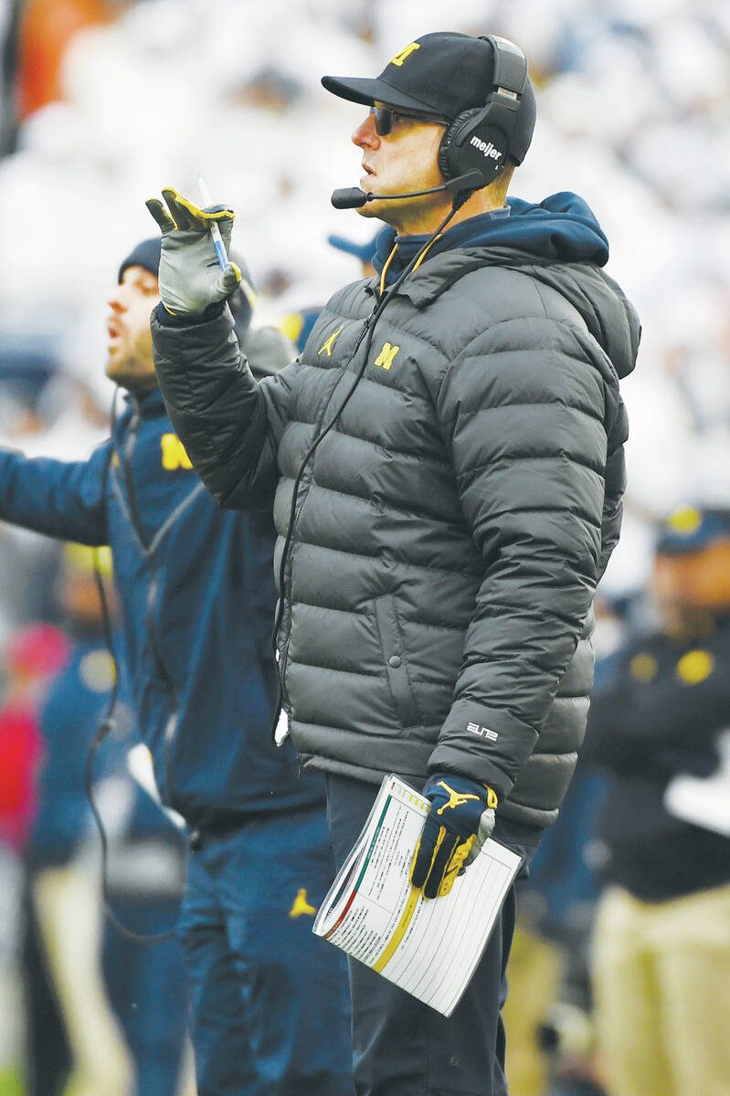 Michigan head coach Jim Harbaugh watches from the sideline during an NCAA college football game ...
