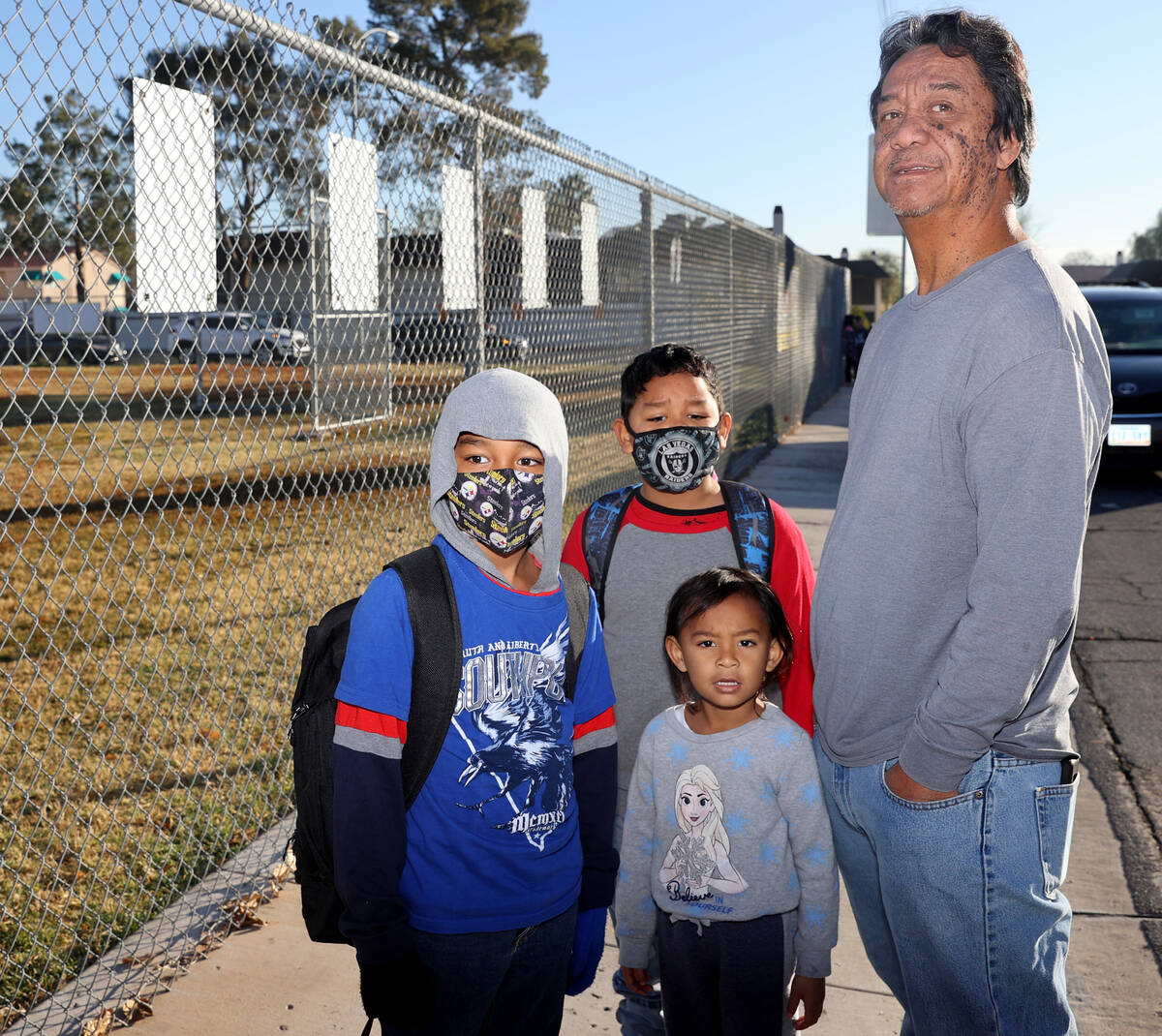 Raynard Marinas drops his kids Kade, 7, left, and Rayden, 6, off at Rowe Elementary School in L ...