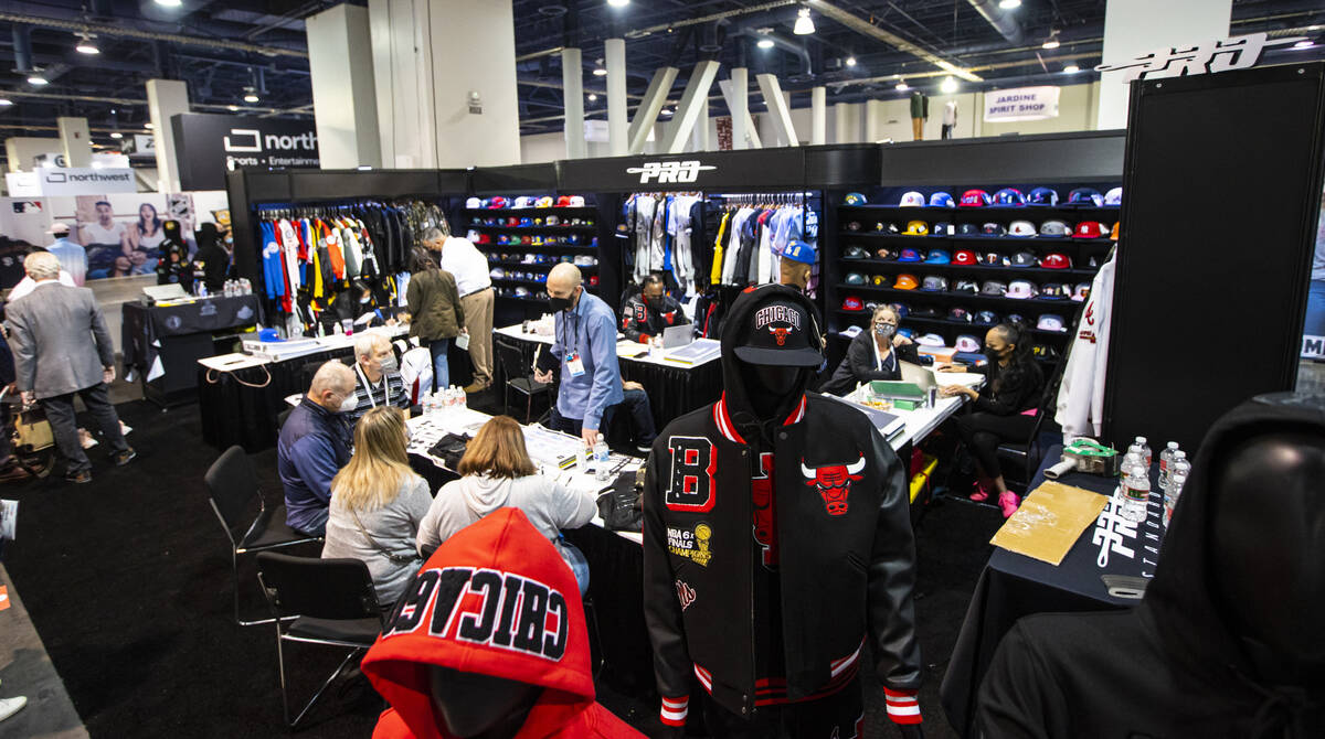 Attendees chat with representatives at the Pro Standard booth during the Sports Licensing & ...