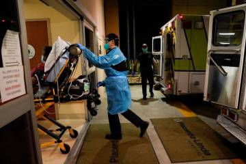 Emergency medical technician Thomas Hoang, 29, of Emergency Ambulance Service, pushes a gurney ...