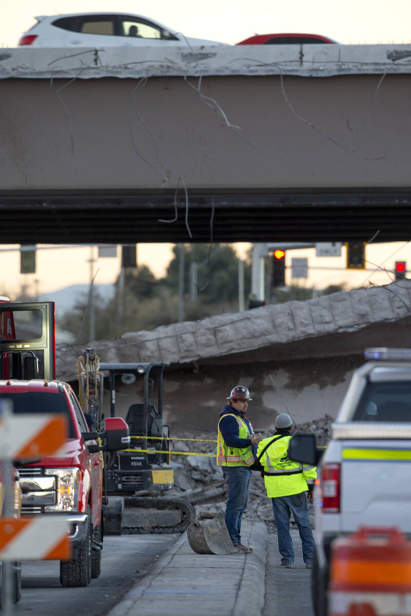 Las Vegas Paving Corp. employees survey the damage after a portion of a bridge on U.S. 95 over ...