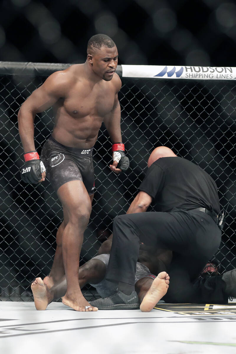 Francis Ngannou, left, walks alway after knocking out Jairzinho Rozenstruck in the first round ...