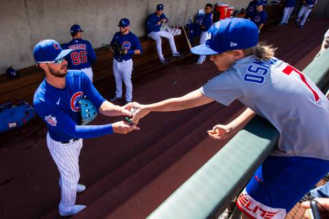 Chicago Cubs' Kris Bryant signs a baseball for Colton Osmulski, 9, of Denver, before the start ...