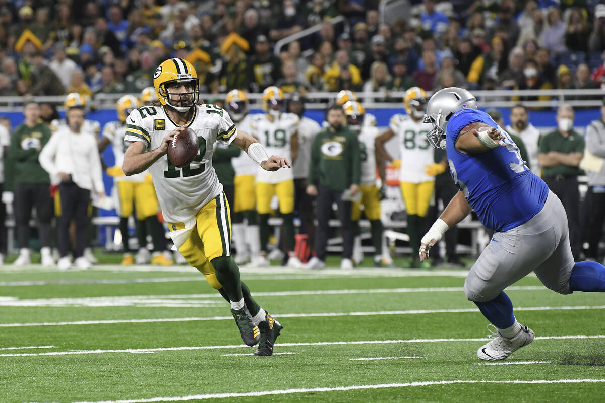Green Bay Packers quarterback Aaron Rodgers (12) scrambles during the first half of an NFL foot ...