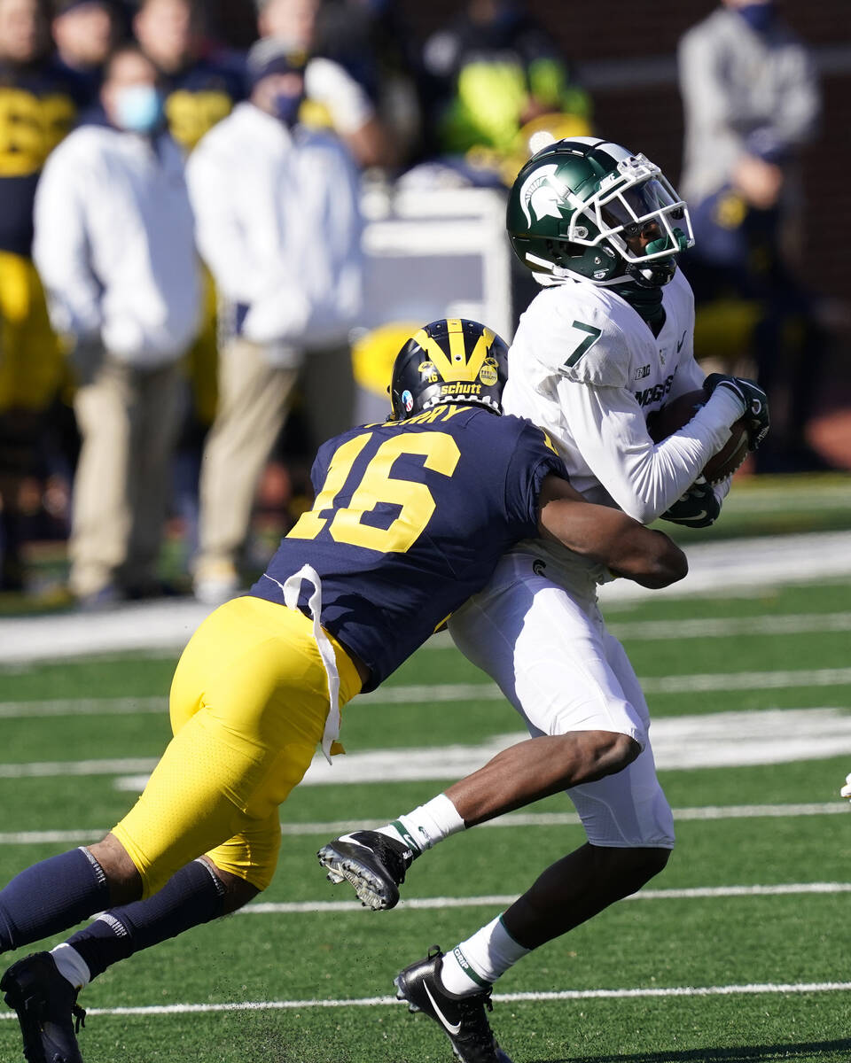 Michigan State wide receiver Ricky White (7) is tackled by Michigan defensive back Jalen Perry ...
