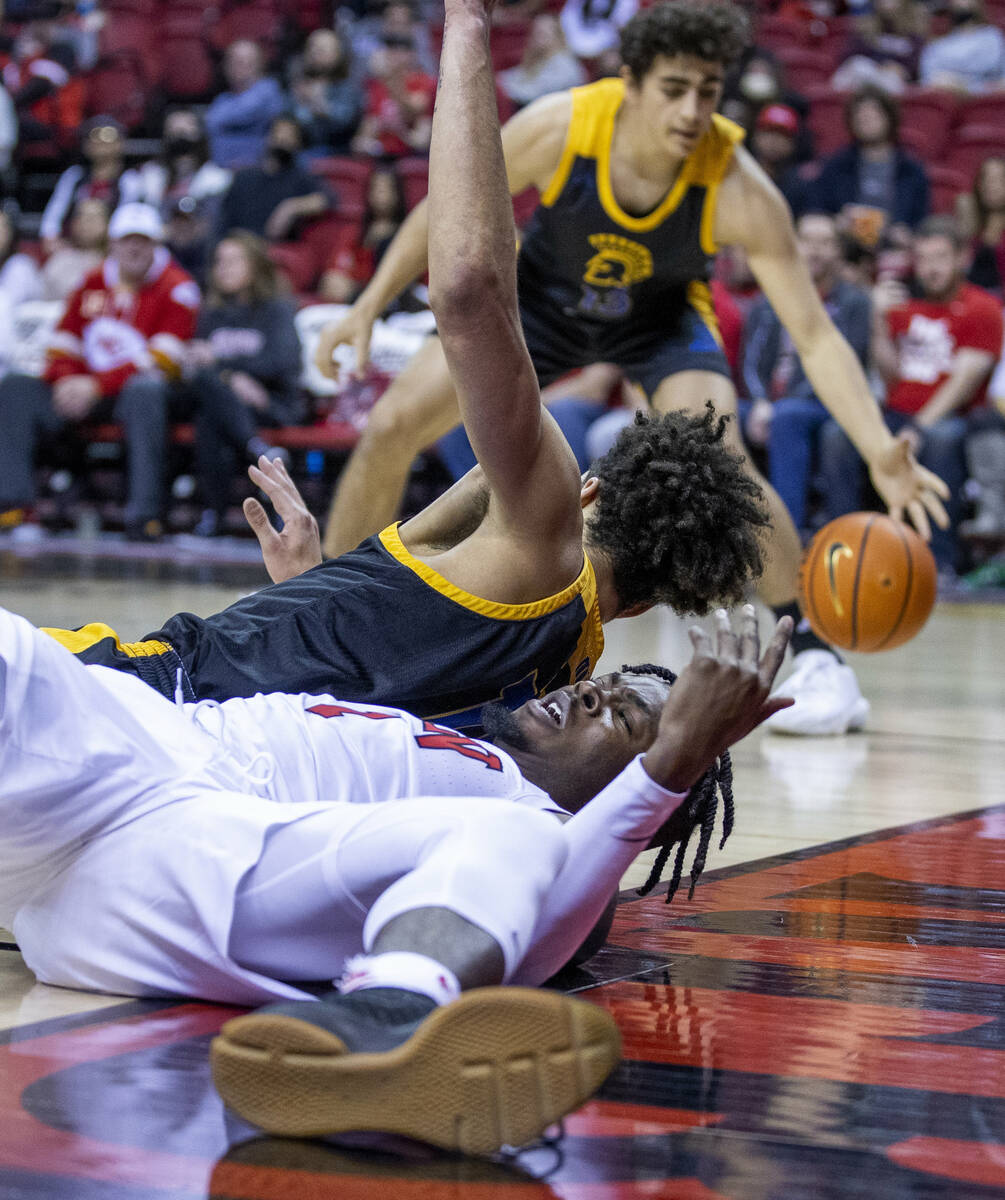 UNLV Rebels guard Michael Nuga (1) loses the ball after tripped up driving to the basket by San ...