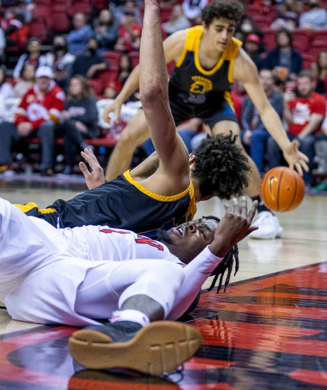 UNLV Rebels guard Michael Nuga (1) loses the ball after tripped up driving to the basket by San ...