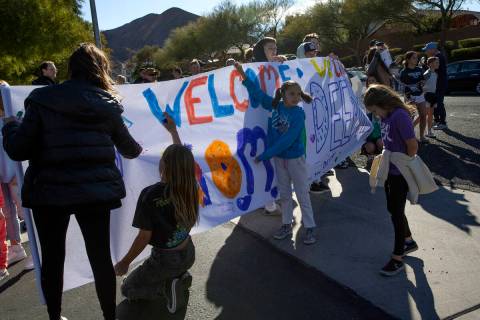 A group puts the finishing touches on a sign to welcome Deedra Russell, who is returning home w ...