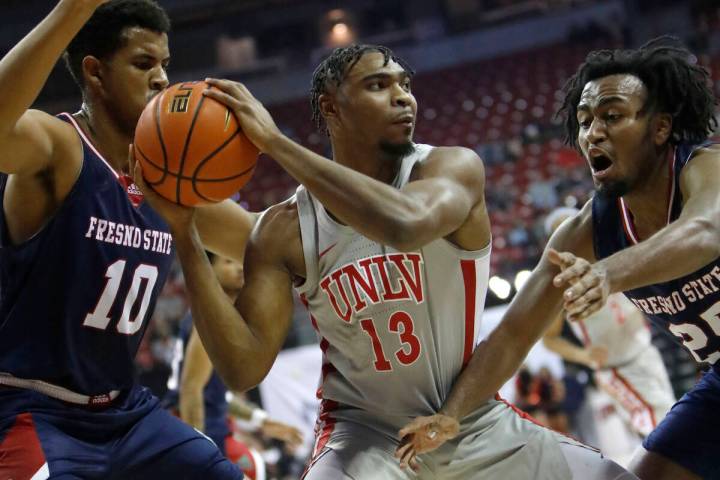 UNLV Rebels guard Bryce Hamilton (13) keeps a ball away from Fresno State Bulldogs forward Orla ...