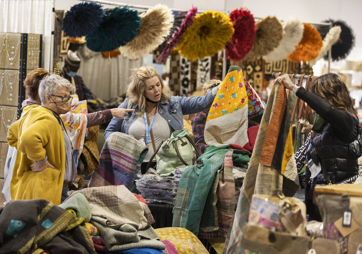 Tony Garza, middle, with Wildfire Design, shops for rugs during the Las Vegas Market at World M ...