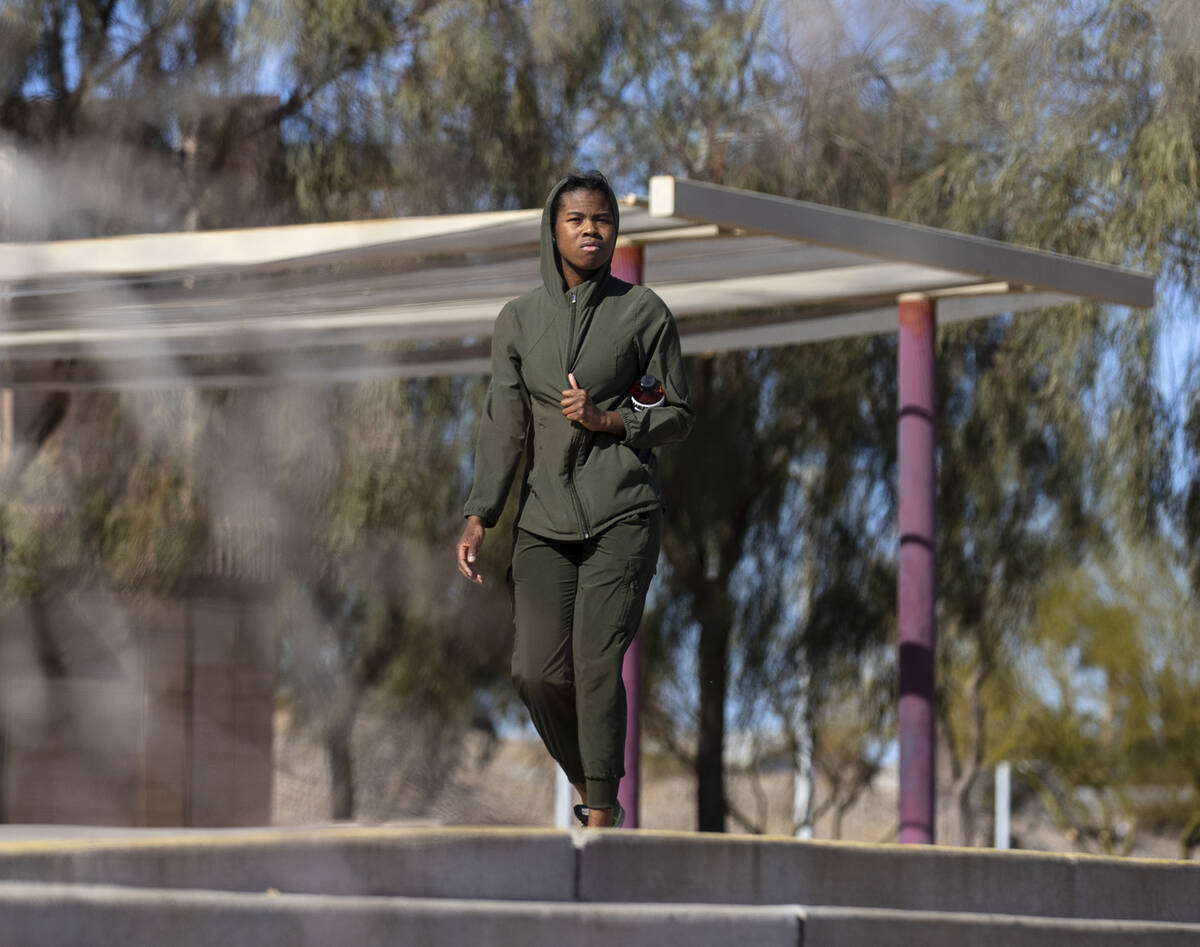 A woman is bundled up as she walks at Cornerstone Park in Henderson on a windy day, Tuesday, Ja ...