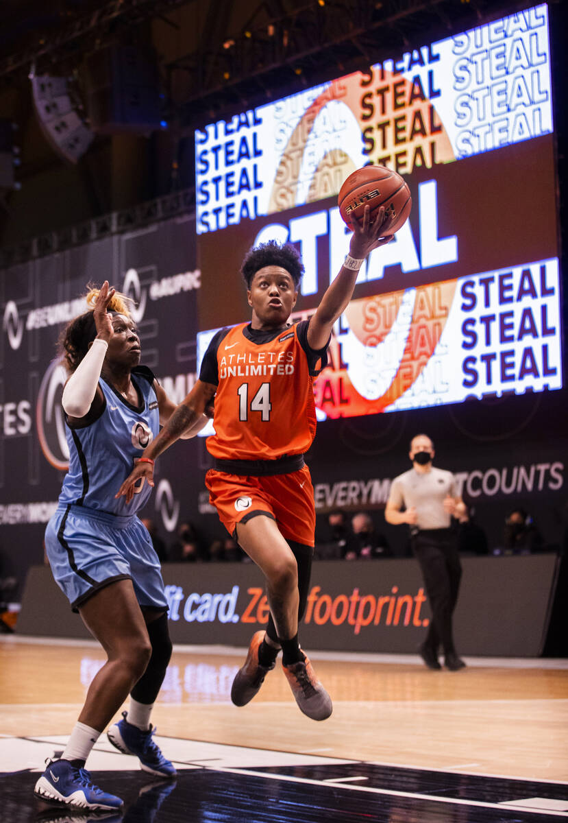 Team Russell’s Taj Cole (14) drives past Team Sims’ Essence Carson (5) during an ...