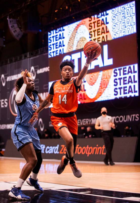 Team Russell’s Taj Cole (14) drives past Team Sims’ Essence Carson (5) during an ...