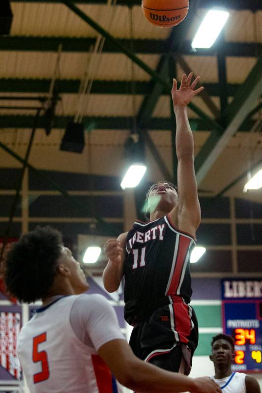 Liberty’s Dedan Thomas (11) shoots while Bishop Gorman’s Darrion Williams (5) and ...